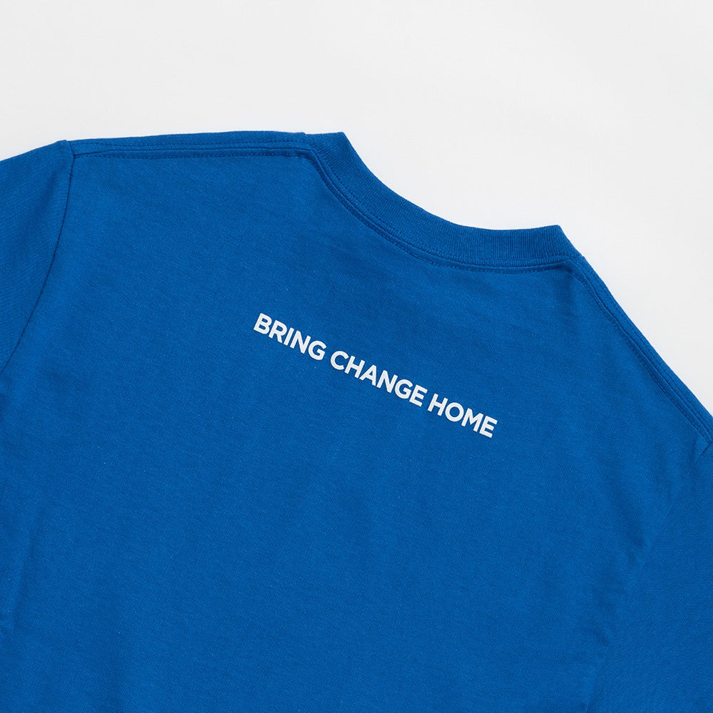 The Obama Presidential Center Symbol T-shirt is royal blue and features "BRING CHANGE HOME," inspired by the Obama Foundation, in bold white letters across the upper back.