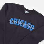 The Obama Presidential Center Chicago Script Sweatshirt is a black sweatshirt with CHICAGO in bold blue letters and "Bring Change Home" in white script, reflecting the center’s inspiring spirit.
