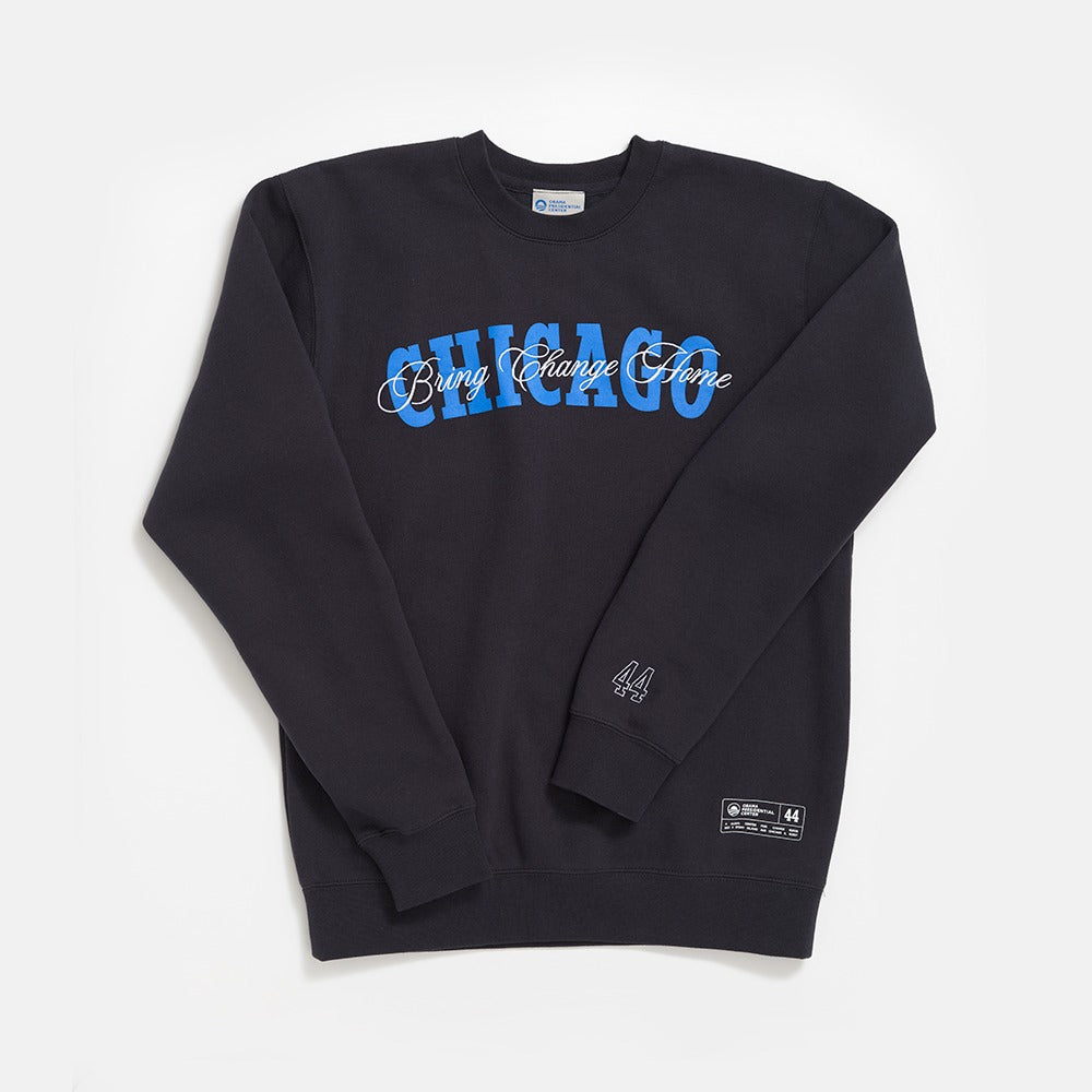 The Obama Presidential Center Chicago Script Sweatshirt is black, with bold blue CHICAGO and white "Bring Change Home" script on the chest, plus a small 44 and text patch near the hem. Laid flat for display.