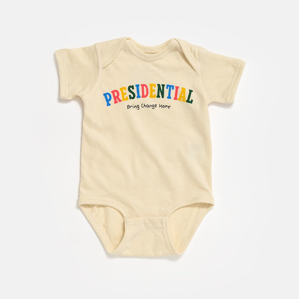The Obama Presidential Center Infant Onesie is a beige, short-sleeve bodysuit with "PRESIDENTIAL" in colorful letters and “Bring Change Home” below, inspired by the Obama Foundation. Laid flat on a white background.
