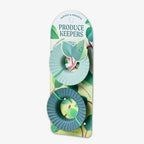Two green, round Produce Keepers are attached to packaging labeled “HARVEST & PRESERVE PRODUCE KEEPERS” with leaf and plant designs—ideal for eco-friendly storage to keep produce fresh longer.