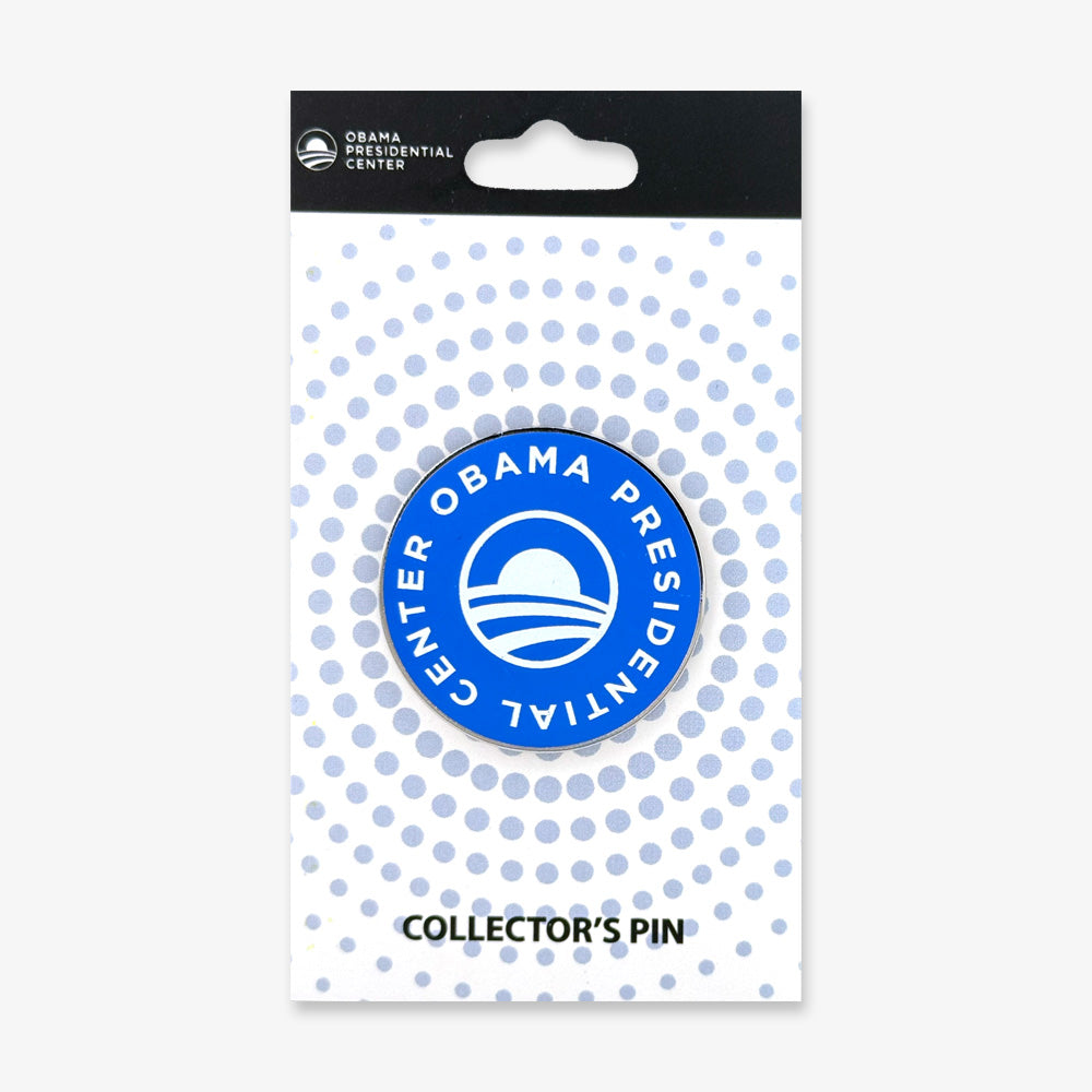 The Obama Presidential Center Collector's Pin features a blue circular design with the official logo and text, attached to a white backing card with blue dots and "COLLECTOR'S PIN" at the bottom—a perfect keepsake for any Obama Foundation fan.