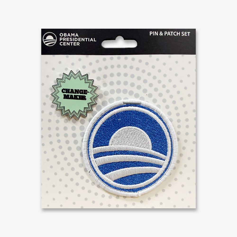 The Obama Presidential Center Stickers Pin & Patch Set includes the CHANGE-MAKER enamel pin and an embroidered patch with a stylized blue and white sun rising over stripes.