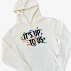 The Obama Presidential Center Stickers Youth Hooded Sweater is a white hoodie with a hood and front pocket, displaying “ITS UP TO US” in bold and colorful words like Unity, Kindness, Hope, and Courage surrounding the main text.