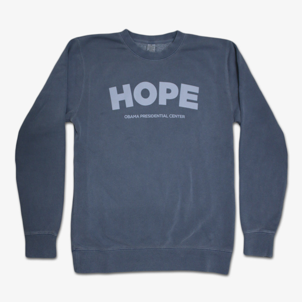 A black vintage crewneck Obama Presidential Center Hope Sweatshirt, featuring bold light "HOPE" lettering and "Obama Presidential Center" below. Classic style to show your support for the Obama Foundation.