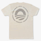 The Obama Presidential Center Hope to Action T-Shirt – Ivory features a large circular logo on the back with a rising sun, stripes, and words like RESILIENCE, HOPE, and COMMUNITY inspired by the Obama Foundation.