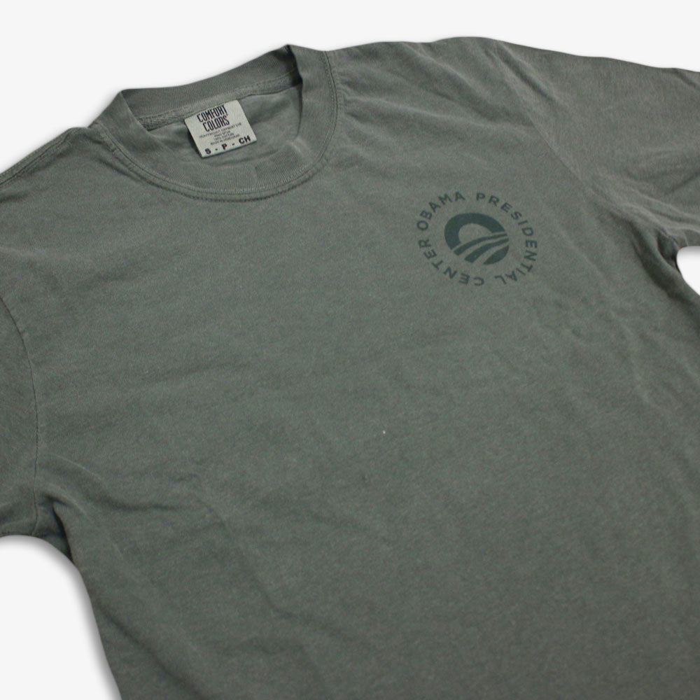 The Obama Presidential Center Hope to Action T-shirt is a gray tee featuring the circular center logo on the left chest, laid flat to display the front design and collar with visible tag.
