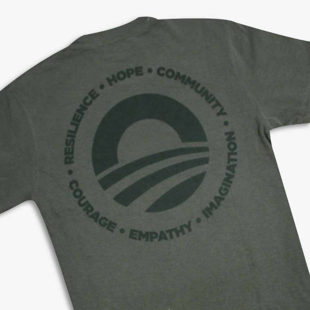 The Obama Presidential Center Hope to Action T-shirt is a gray tee with a back circular logo featuring a sunrise graphic and the words: Resilience, Hope, Community, Courage, Empathy, Imagination—inspired by the Obama Foundation.