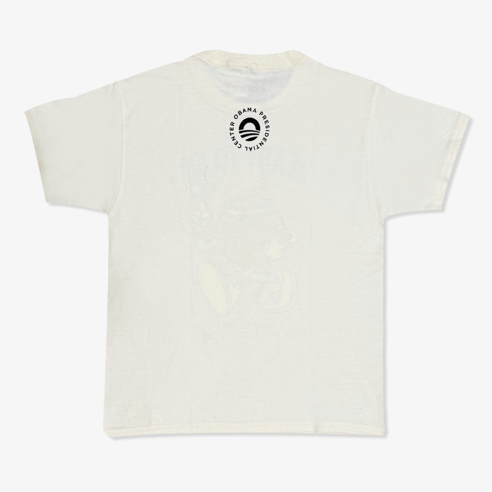 The Obama Presidential Center Home Court Youth T-Shirt in a light hue is shown from the back, with a circular logo near the collar reading “Obama Presidential Center” and featuring a stylized O in the center.