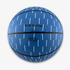 Introducing the Obama Presidential Center Blue Basketball—a kids-size basketball in a striking blue shade with light blue vertical dash patterns, black seams, and "WE ARE THE FUTURE" printed above sizing and manufacturing details. This exclusive piece is part of the Home Court collection for the Obama Presidential Center.