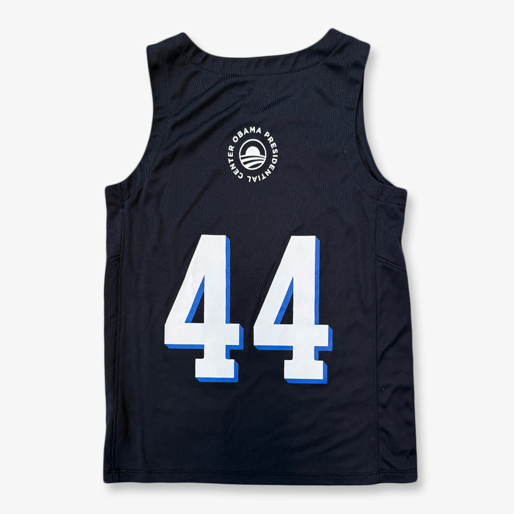The Obama Presidential Center Home Court Youth Jersey is a black sleeveless basketball jersey with bold white/blue 44 on the back and a circular Obama Presidential Center logo above—part of the exclusive Home Court collection.