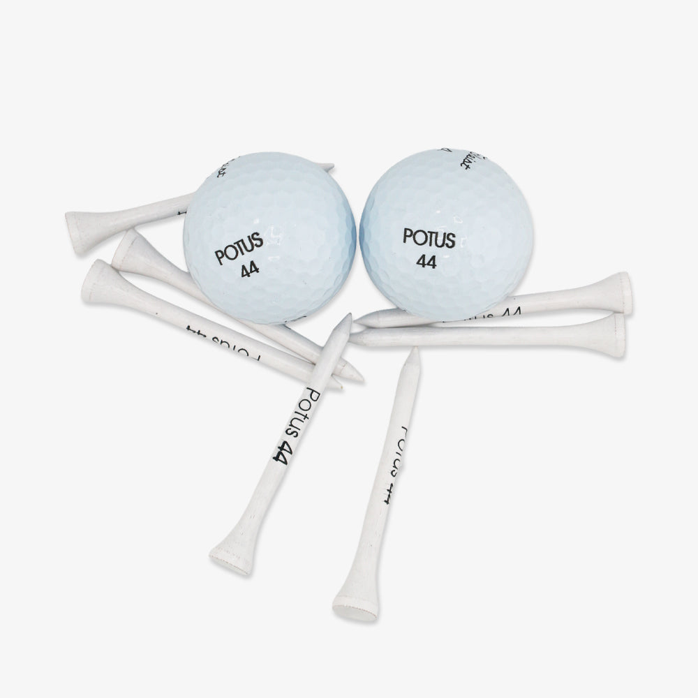 The Obama Presidential Center Golf Tees set includes two white golf balls and multiple tees, each marked POTUS 44, arranged on a plain white background—a subtle tribute to the Obama Foundation.