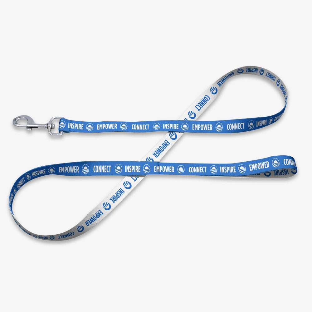 The Obama Presidential Center Pet Leash is blue and white, with "INSPIRE," "EMPOWER," and "CONNECT" repeatedly printed along its length. It features a sturdy metal clasp at one end.