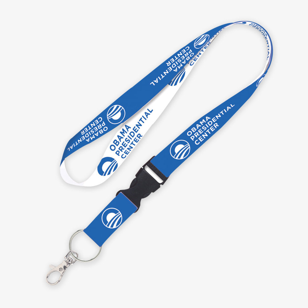 The Obama Presidential Center Home Court Lanyard is blue and white, reversible, and features the Center’s text and logo along the strap. This official merchandise includes a metal swivel hook and black plastic buckle for attaching items.
