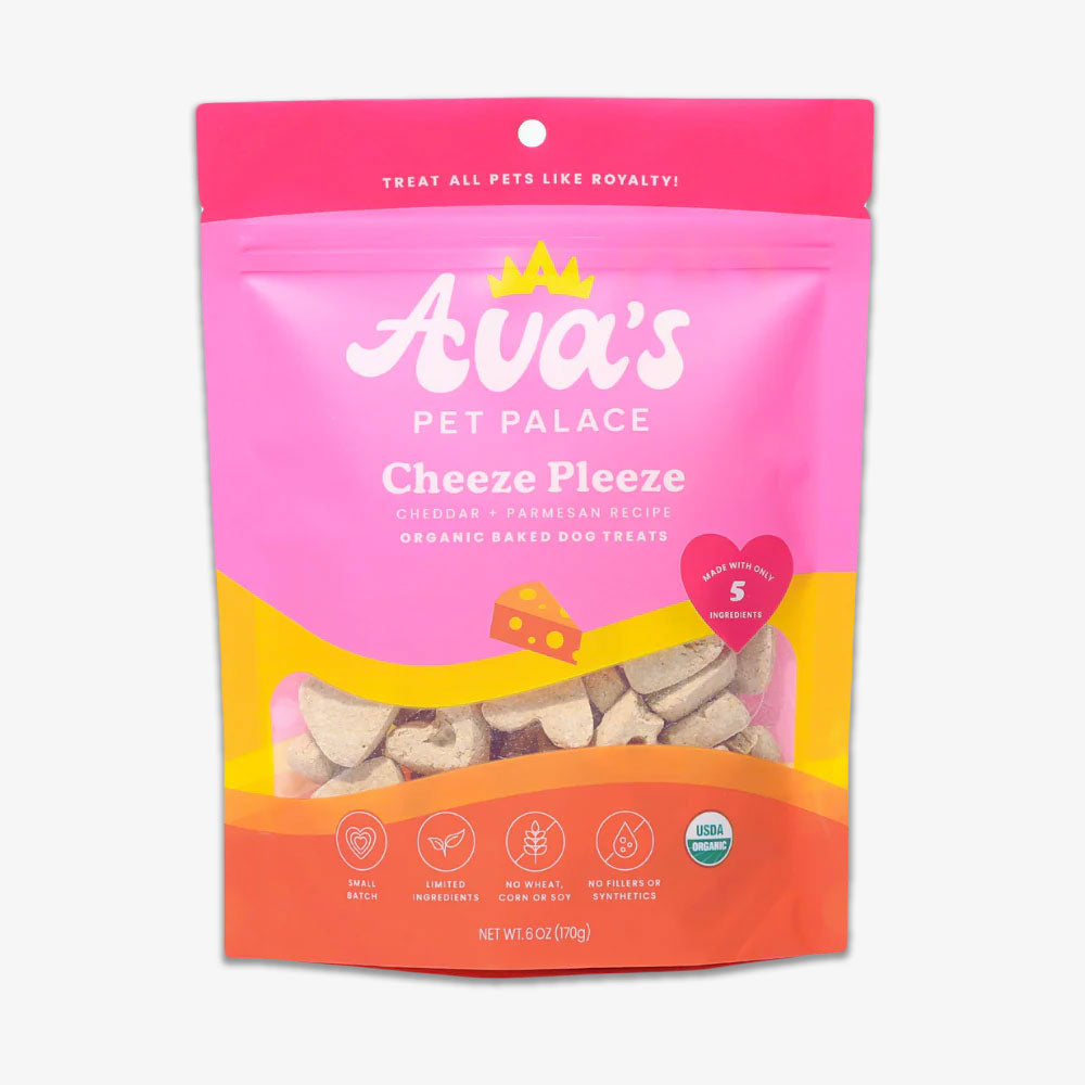 A 6 oz pink and yellow bag of Cheeze Pleeze Organic Baked Dog Treats, cheddar and parmesan recipe, displays heart-shaped treats through a clear window. Package features USDA organic and ingredient labels.