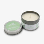 A round tin Empower Sprig Candle 4 oz. with a white hand-poured soy candle inside. The lid reads "bright endeavors" and "Dream Residential Center." Supported by the Obama Foundation.