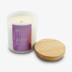 The Inspire Sprig Candle 9 oz. features hand-poured lavender wax in a frosted glass jar labeled "Inspire" with a purple floral design, accompanied by a round wooden lid, set against a white background.