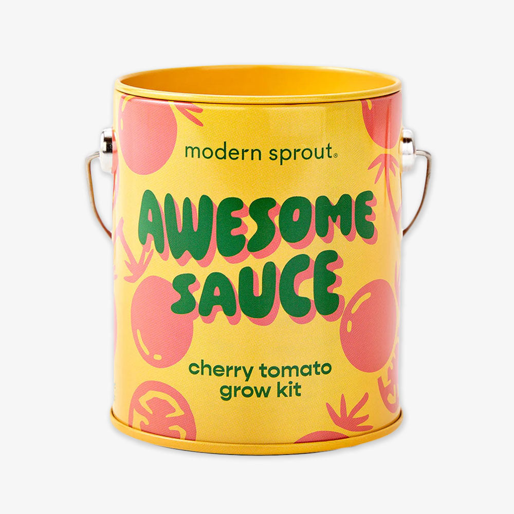 A yellow and orange tin can labeled "Awesome Sauce Grow Kit" features cartoon tomatoes and a silver handle. This reusable planter grows organic cherry tomatoes, perfect for a bright, playful mini-harvest indoors or outdoors.