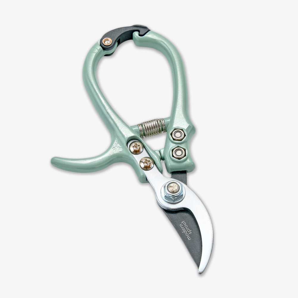 The Gardening Pruners feature a light green handle, durable bypass blade, curved stainless steel edge, and spring mechanism, shown on a plain white background.