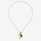 The Gemstone Mix Charm Necklace features a gold paperclip chain with three charms—a gold disk, blue rectangular gemstone, and white pearl—offering modern, sustainable artisan style ideal for everyday wear.