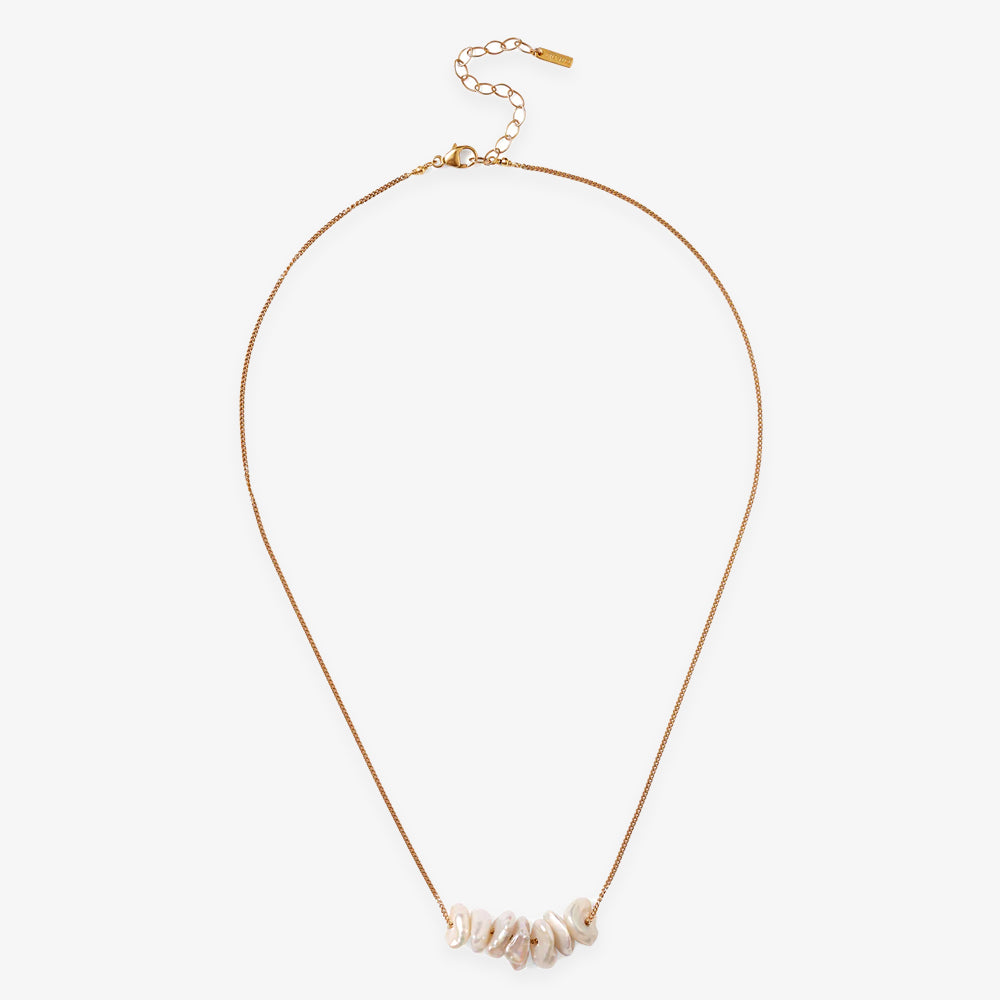 The Gold Pearl Chip Necklace features elegantly irregular white pearls on a gold-plated sterling silver chain, complete with an adjustable clasp and extender for the perfect fit.