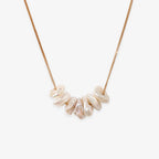 The Gold Pearl Chip Necklace features a gold plated sterling silver chain with several irregularly shaped white keshi pearls strung at the center, inspired by Chan Luu’s signature style.