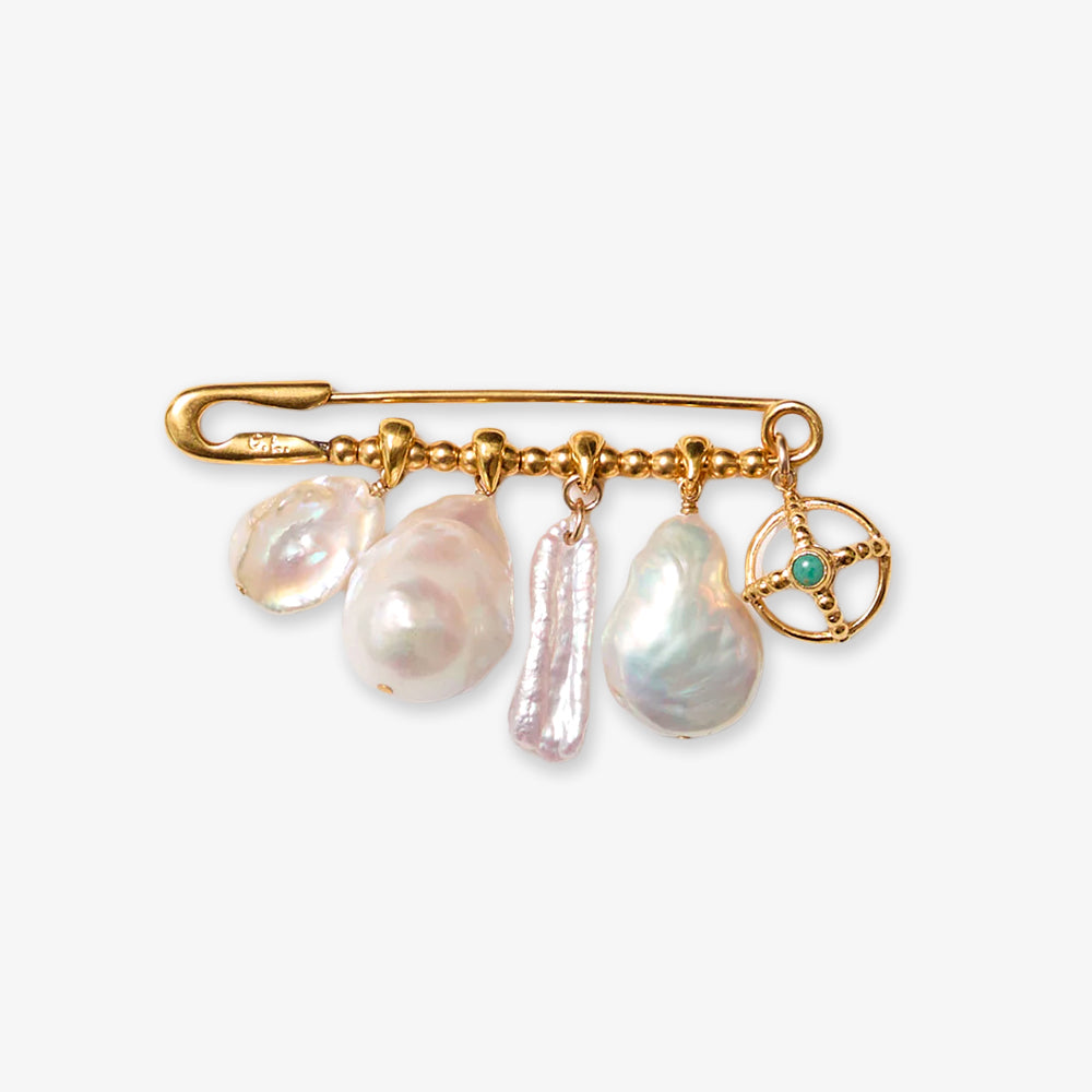 The White Pearl Pin, inspired by Chan Luu, features a gold safety pin with three irregular natural pearls, a rectangular pearl, and a gold star charm set with a small blue gemstone—all set against a plain white background.