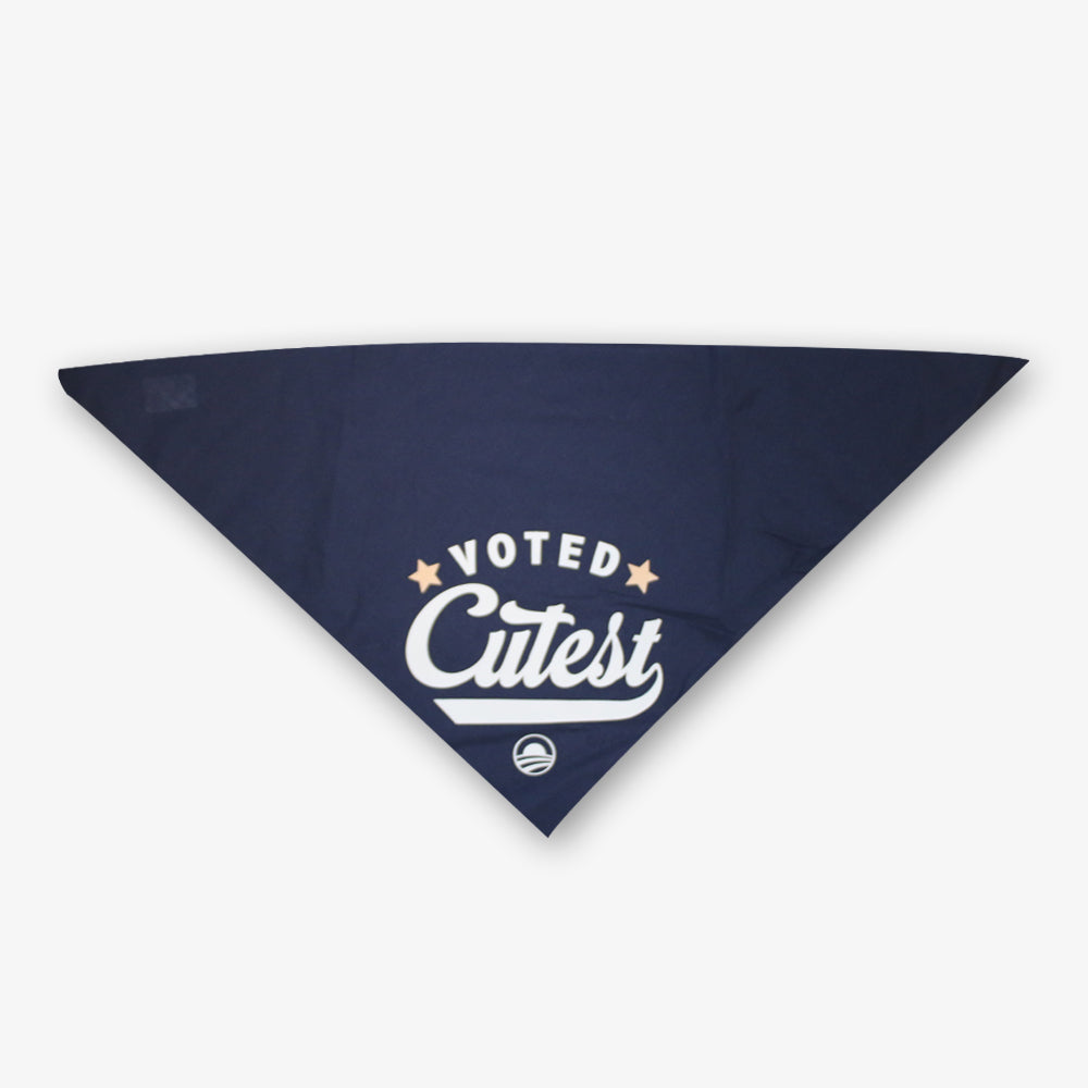 The Voted Cutest Kerchief is a navy dog bandana with "Voted Cutest" in white text, two stars, and a circular logo—an adorable accessory to enhance your pup's style.