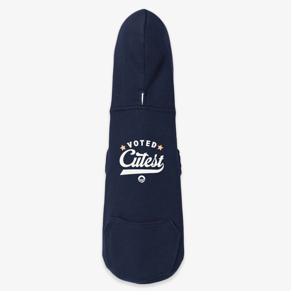 The Voted Cutest Dog Hooded Sweater is a navy blue hoodie with a front pocket and “Voted Cutest” in white and gold on the back—ideal pet apparel for walks by the Obama Presidential Center.