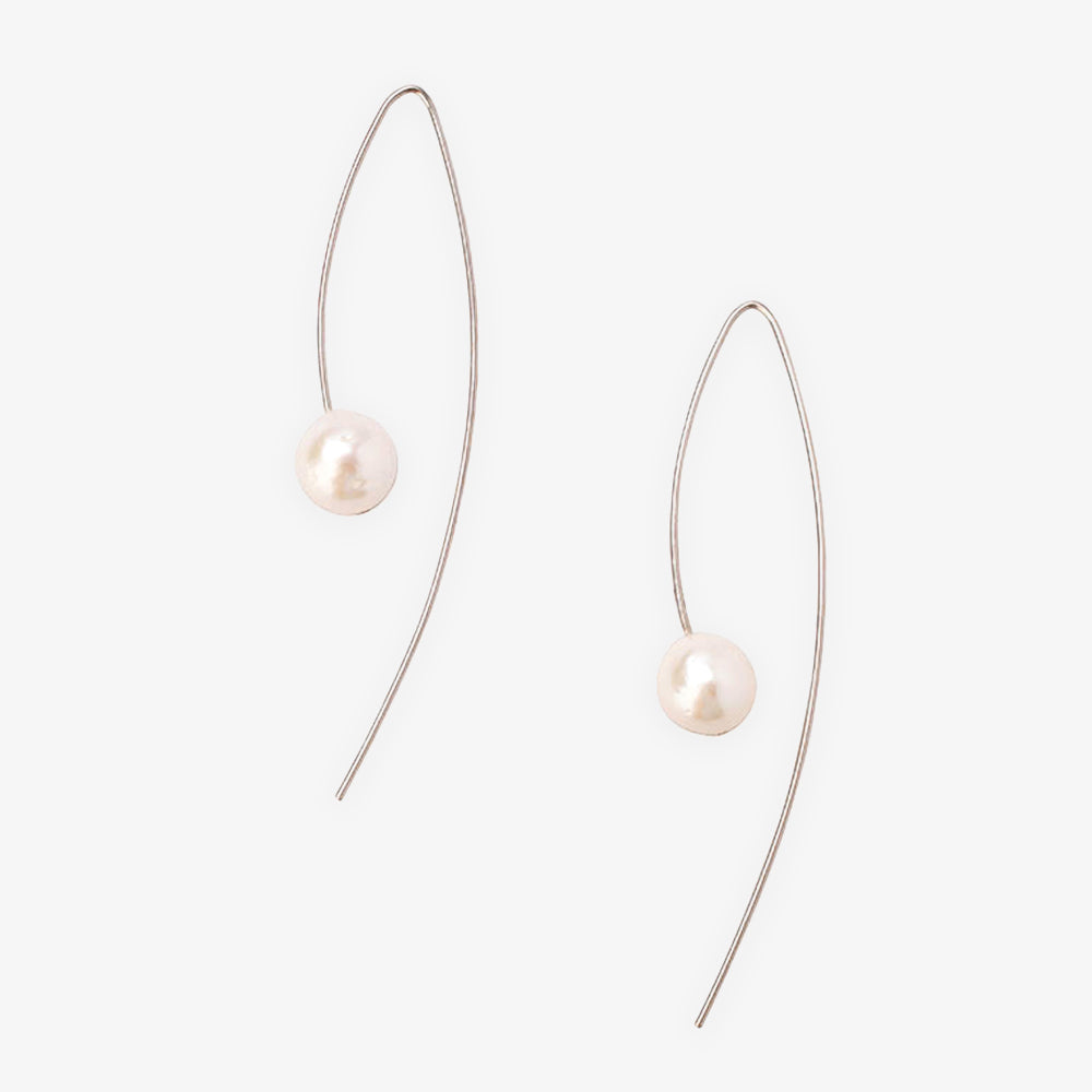 The Michelle Pearl Earrings Silver feature minimalist sterling silver wires, each adorned with a single round freshwater pearl, showcasing Chan Luu’s refined and elegant style against a plain white backdrop.