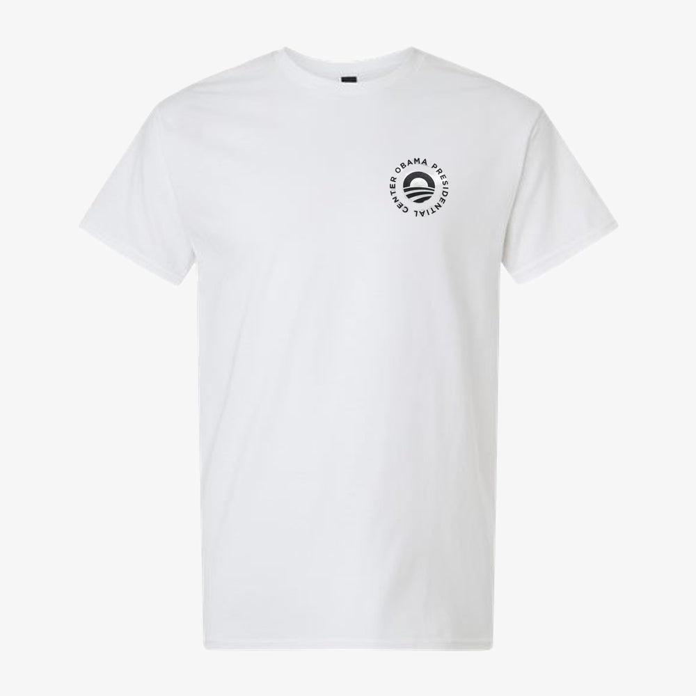 The Bring Change Home Youth T-Shirt is a classic white tee featuring a small circular logo with a stylized O and the words "OBAMA PRESIDENTIAL CENTER" on the upper left chest—a timeless piece from the Obama Foundation that's perfect for inspiring young trailblazers.