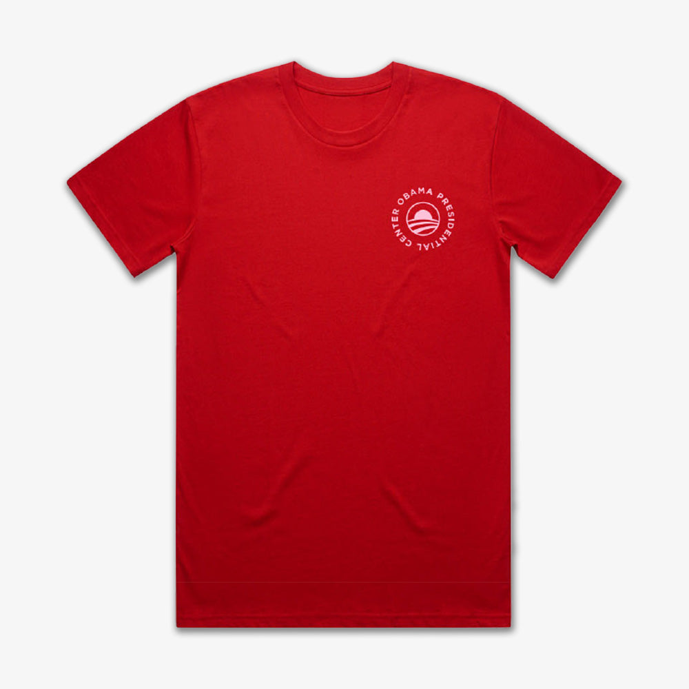 The Obama Presidential Center Hope to Action T-shirt - Sunset is a plain red tee with a small white circular logo on the left chest reading “OBAMA PRESIDENTIAL CENTER” around a stylized O—an inspiring and stylish choice.