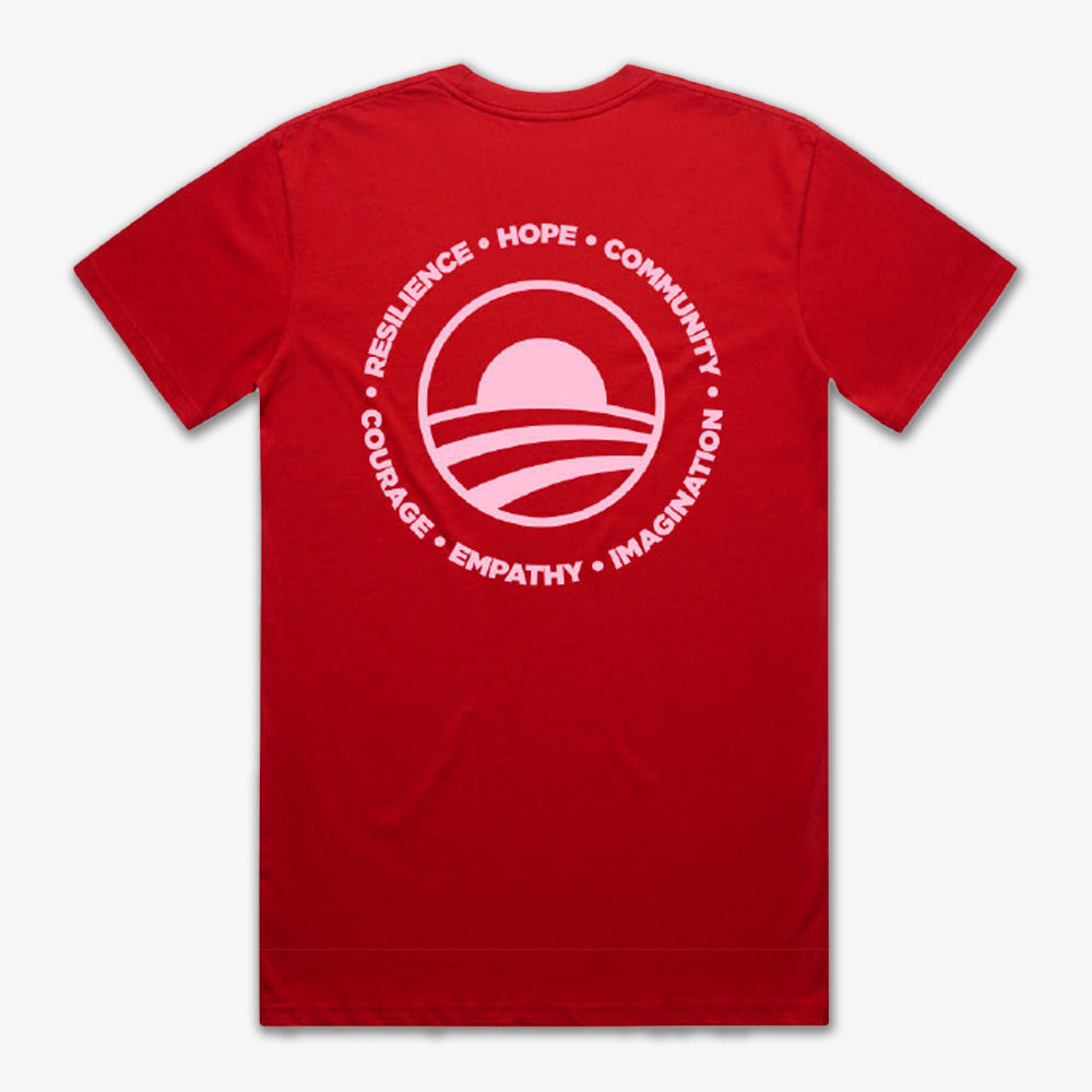 The Obama Presidential Center Hope to Action T-shirt - Sunset is a red tee with a large white circle logo on the back featuring a stylized sunset and waves, along with inspiring words: RESILIENCE • HOPE • COMMUNITY • COURAGE • EMPATHY • IMAGINATION.
