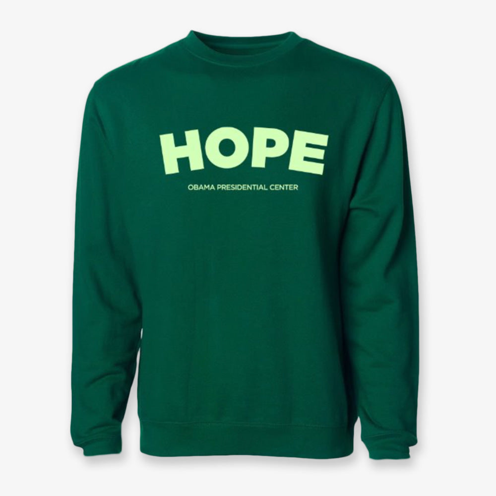 The Obama Presidential Center Hope Sweatshirt - Green features "HOPE" in large yellow letters and "OBAMA PRESIDENTIAL CENTER" in smaller yellow text on the front.