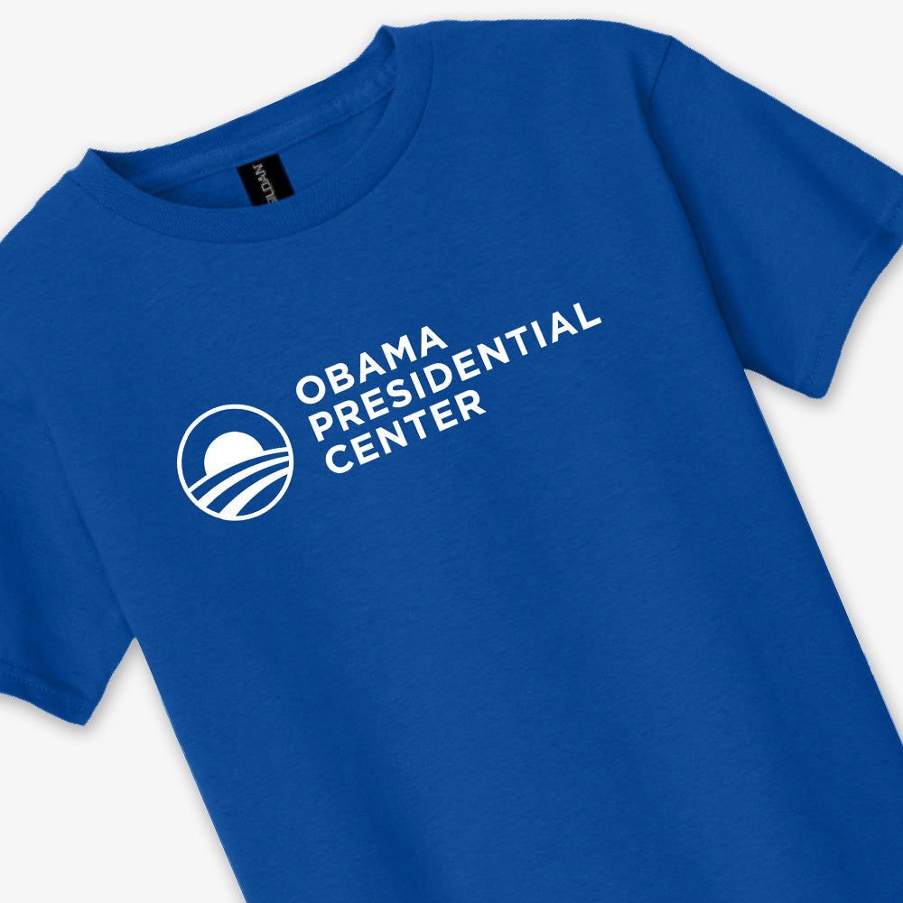 Royal blue youth unisex t-shirt, officially inspired by the Obama Foundation, featuring the Obama Presidential Center and a white circular logo printed on the front. Product name: Obama Presidential Center Logo Youth T-Shirt - Royal.