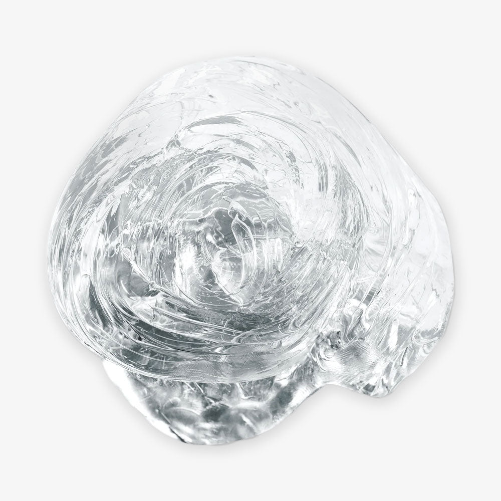 Liquid Glass Putty is a glossy, crystal-clear amorphous blob resembling melted glass or thick gel, shown against a plain white background.