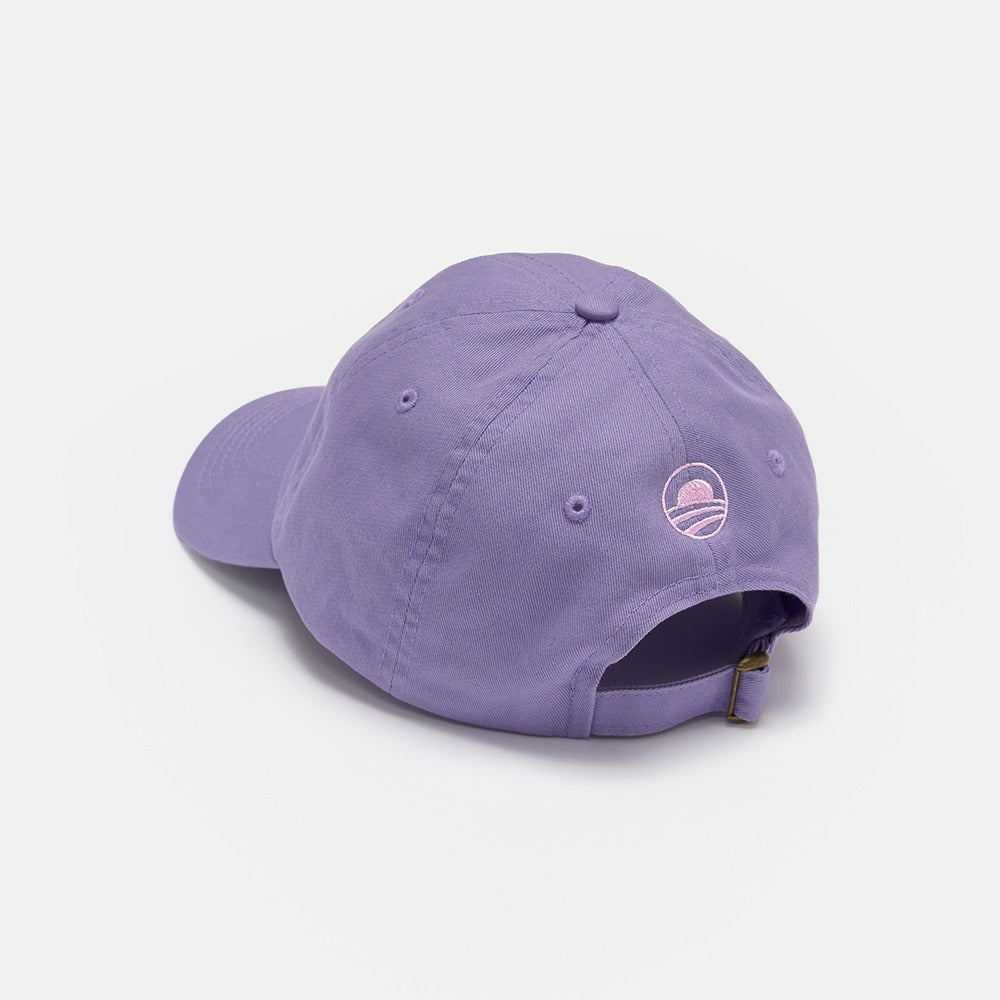 The Obama Presidential Center Empathy Cap is a purple cap with a small embroidered logo above the adjustable strap and buckle, shown from the back on a plain white background.