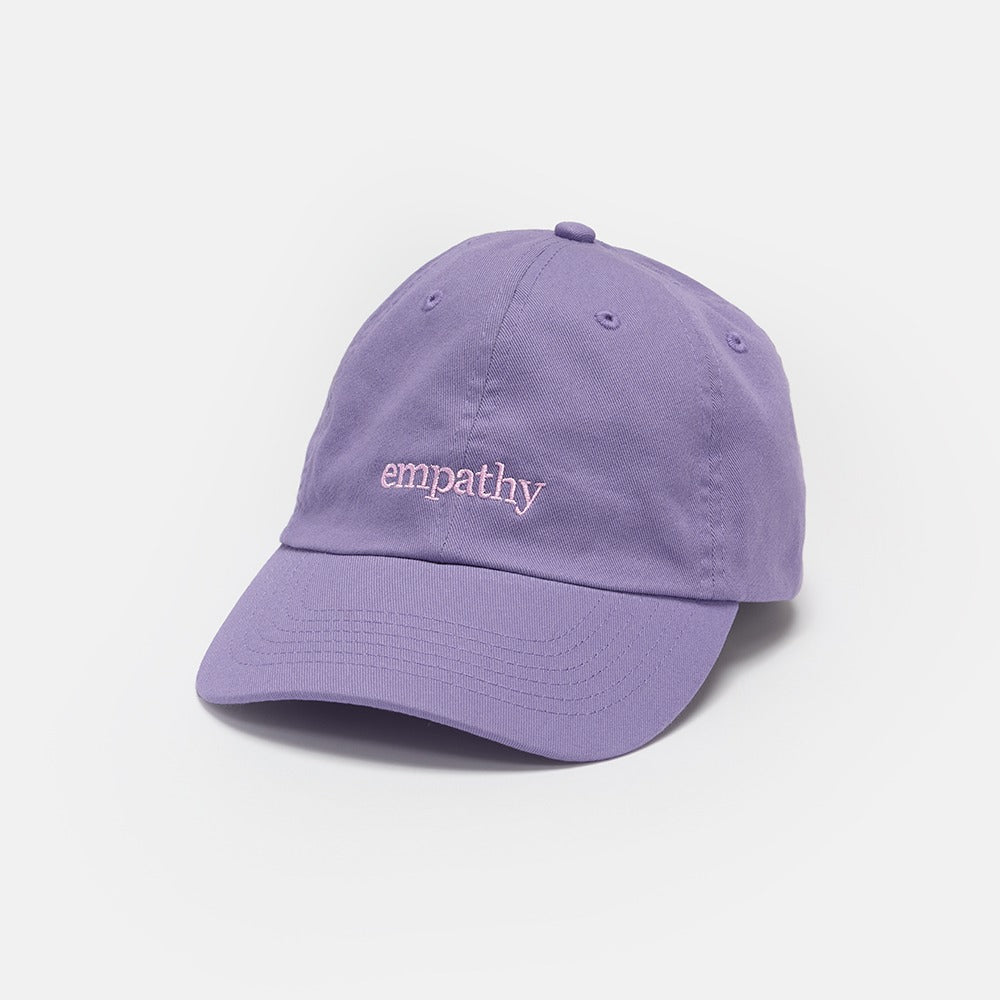 The Obama Presidential Center Empathy Cap is a light purple hat featuring "empathy" embroidered in white on the front, inspired by the Obama Foundation and shown against a plain white background.