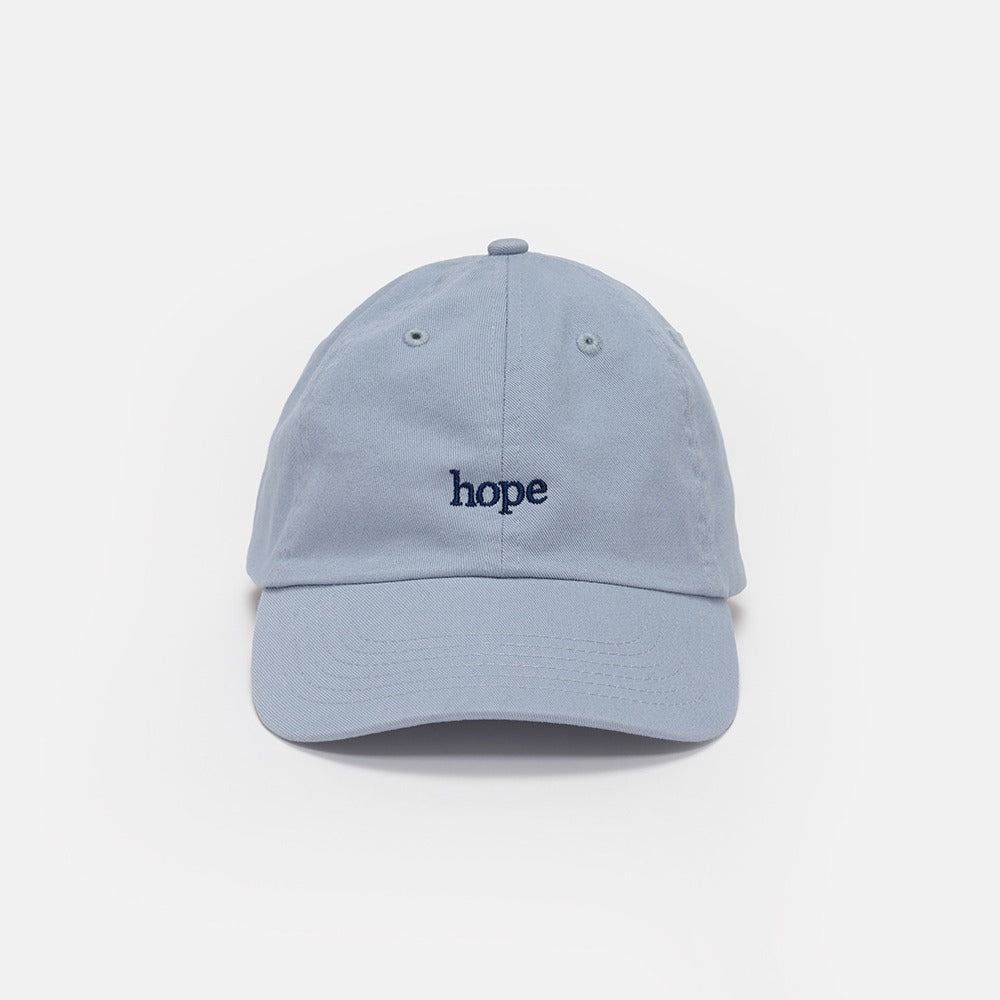 The Obama Presidential Center Hope Cap - Blue features "hope" embroidered in dark blue lowercase letters on a light blue cap, reminiscent of the iconic Obama hat, displayed against a plain white background.