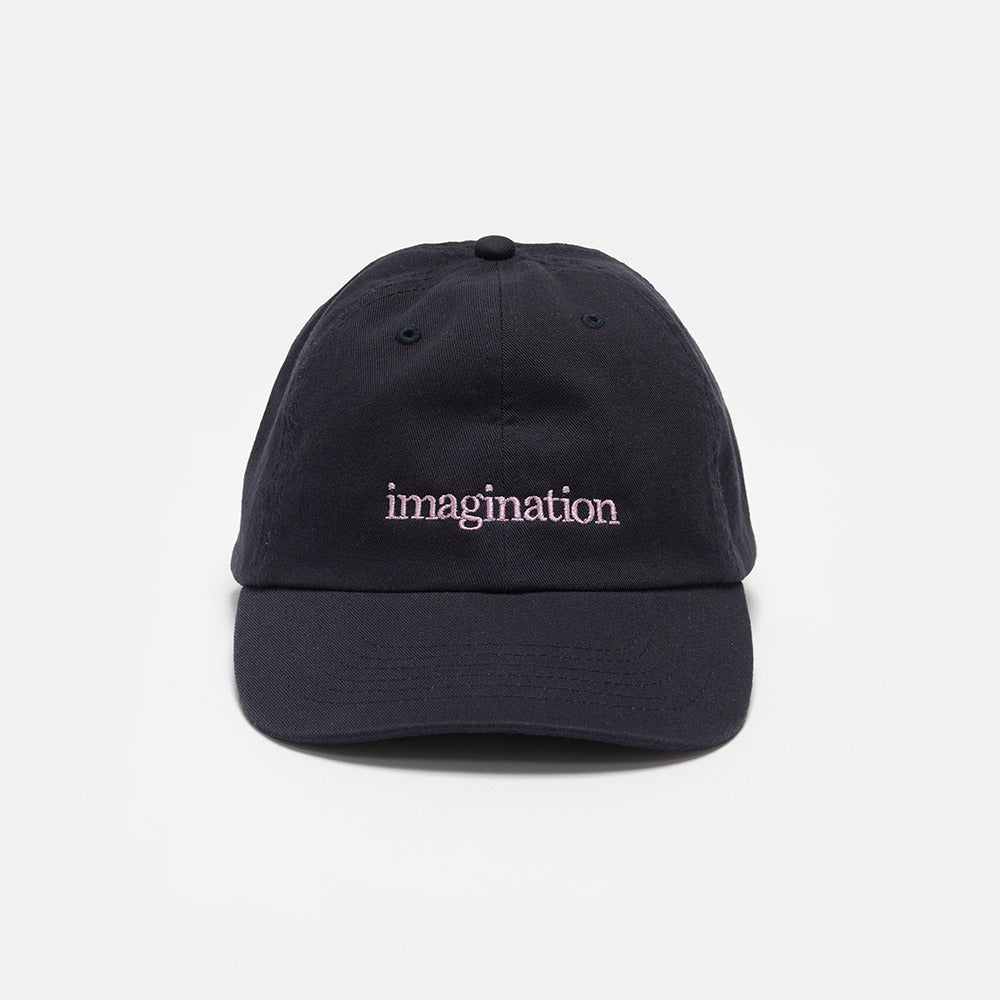 The Obama Presidential Center Imagination Cap is a black baseball cap with "imagination" embroidered in white lowercase letters on the front, shown on a plain light gray background—an ideal unique piece of Obama Foundation merchandise.