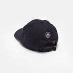 The Obama Presidential Center Imagination Cap in black is shown from the back, highlighting a small pink embroidered logo and an adjustable strap with a brass buckle.