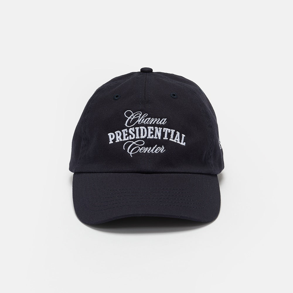 The Obama Presidential Center Embroidered Cap is a black cap with white embroidered text on the front, shown against a plain white background. This official accessory is part of the Obama Foundation collection.