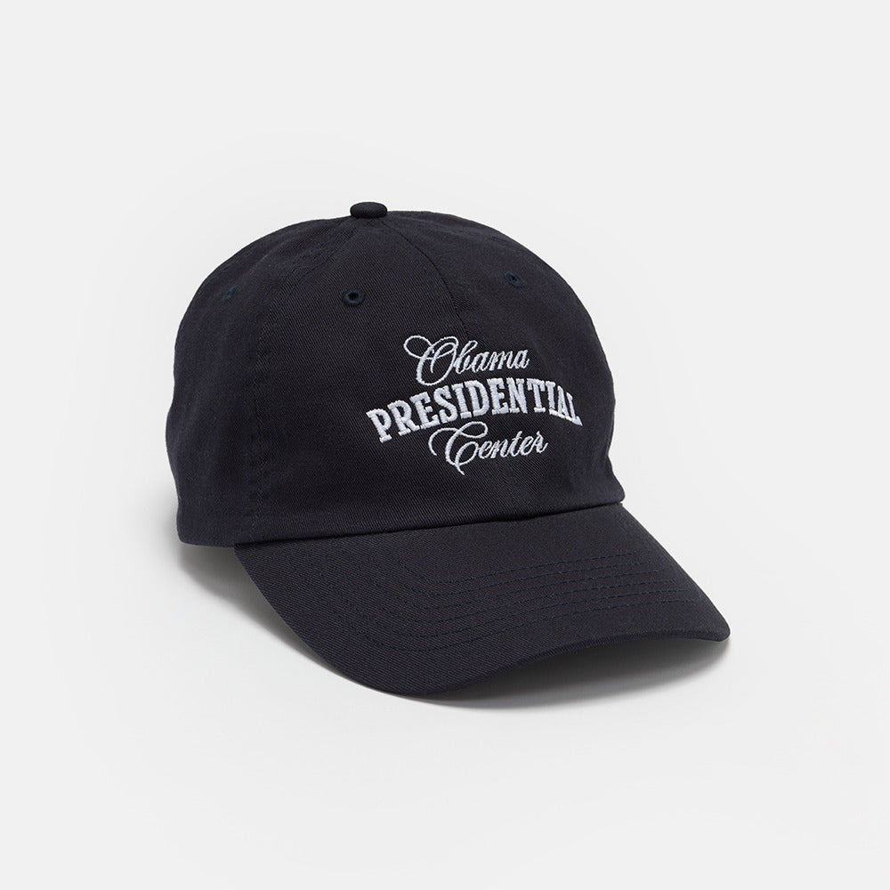 The Obama Presidential Center Embroidered Cap is navy blue with "Obama Presidential Center" in white embroidery on the front, shown against a plain white background.