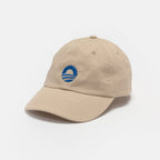 The Obama Presidential Center Symbol Cap is an off-white hat with a curved brim, featuring the official blue circular Obama Foundation logo on the front, shown on a plain white background.