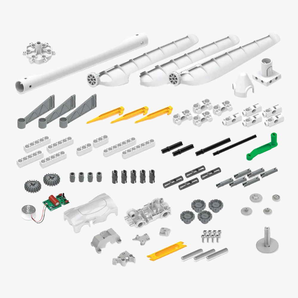 Windpower kit components—including gears, rods, blades, a circuit board, and connectors in gray, white, yellow, and green—are neatly arranged on a white background.