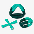 The Evergreen Flex Set includes three teal and dark green rubber dog toys—triangle, oval, and X shapes with smooth edges—ideal for stress relief or as a creative addition to any educational set.