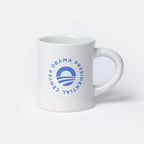 The Obama Presidential Center Logo Mug features a white ceramic design with a blue circular logo and "Obama Presidential Center" text, making it a distinctive keepsake.