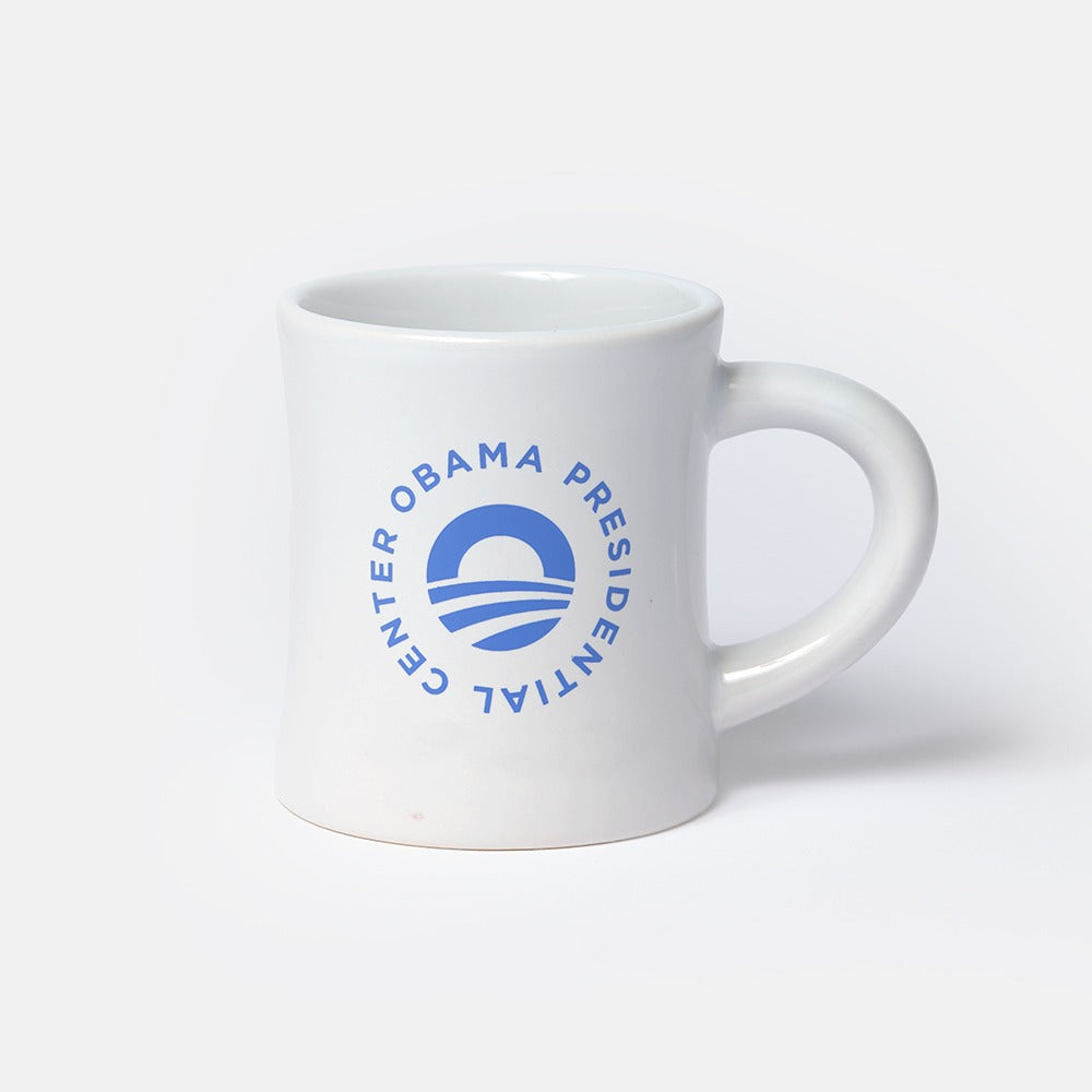 The Obama Presidential Center Logo Mug features a white ceramic design with a blue circular logo and "Obama Presidential Center" text, making it a distinctive keepsake.