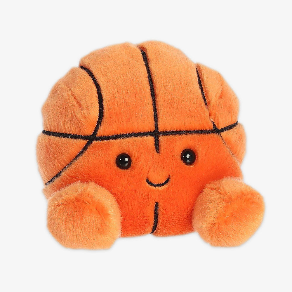 The Palm Pal Hoops Basketball Plush is an orange, fuzzy basketball toy with black stitched lines, two round feet, and a smiling face with black eyes—a fun keepsake inspired by the Obama Foundation.