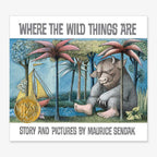 Book cover of Where the Wild Things Are, showing a boat on water near a large, furry horned creature under pink palm trees, with a gold medal on the left side.